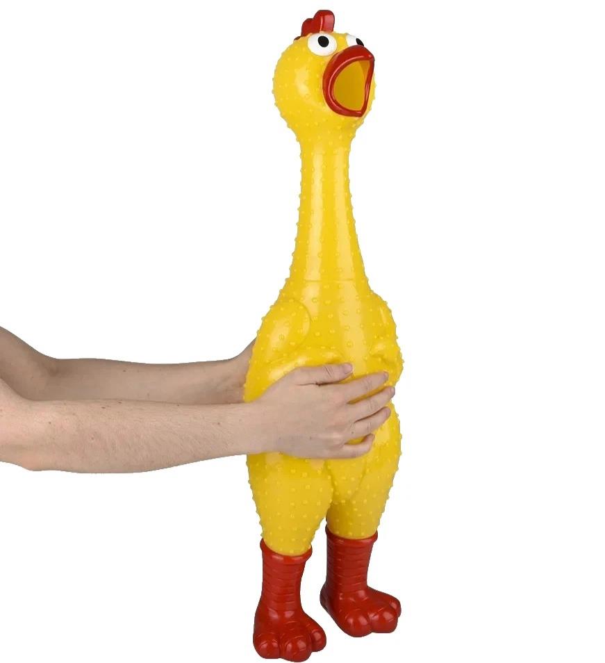 A person holding the 🐔 GIANT 27" Rubber Chicken, the biggest and loudest squeaky toy—a hilarious gag gift featuring yellow rubber, red feet, a red comb, and an open beak.