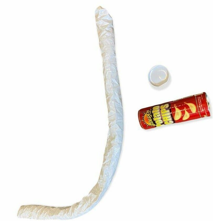 A partially crumpled can of Potato Chips Snake Can Spring Pop - Fun Classic GaG Prank Joke Clown Party Toy, with its detached white lid, lies next to a long, crumpled piece of white paper on a white background. It looks like a classic gag, perhaps even the infamous prank pulled off to perfection.