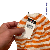 Hand holding a Stylish Genuine Le Tigre Knit Hat Winter Beanie in orange and white 100% acrylic, with a tag attached showing the brand "Le Tigre" and a price of $24.