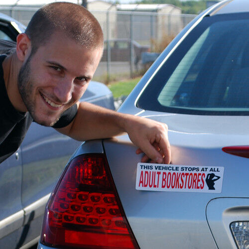 A man smiles while pointing at a hilarious magnetic bumper sign on a car that reads, "THIS VEHICLE STOPS AT ALL ADULT BOOKSTORES," from the "4 Prank Car Magnets - I Love Porn, Closet Queen, Adult Bookstores, etc FUNNY!!!" set.