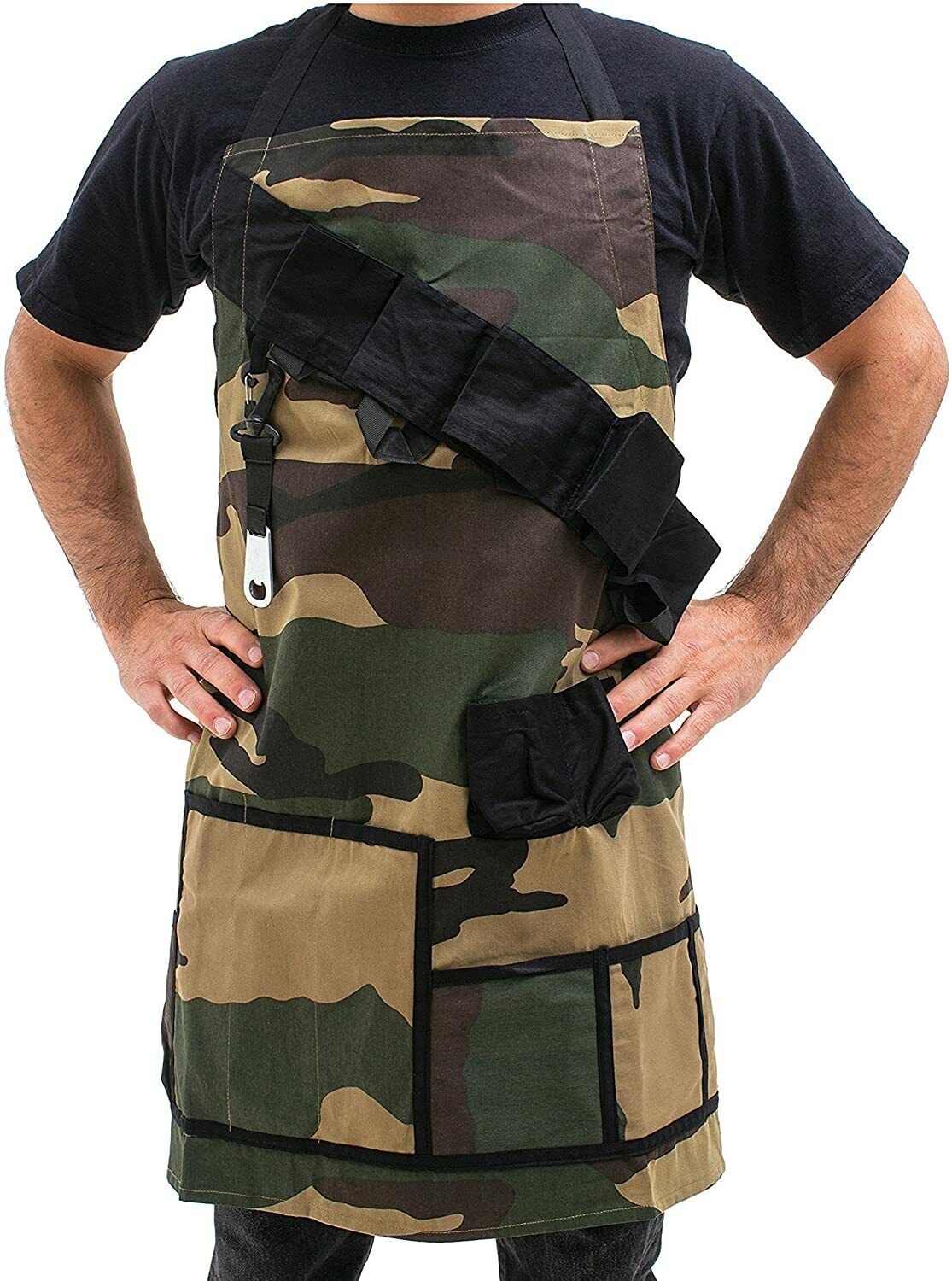 A person wearing THE GRILL SERGEANT BBQ APRON, featuring a camouflage design with multiple pockets and a black strap across the chest, stands against a plain background. This fun gag gift, also known as the perfect Barbeque Party Gift Prank Beer Holder Humor Joke, is ideal for any outdoor cooking enthusiast.