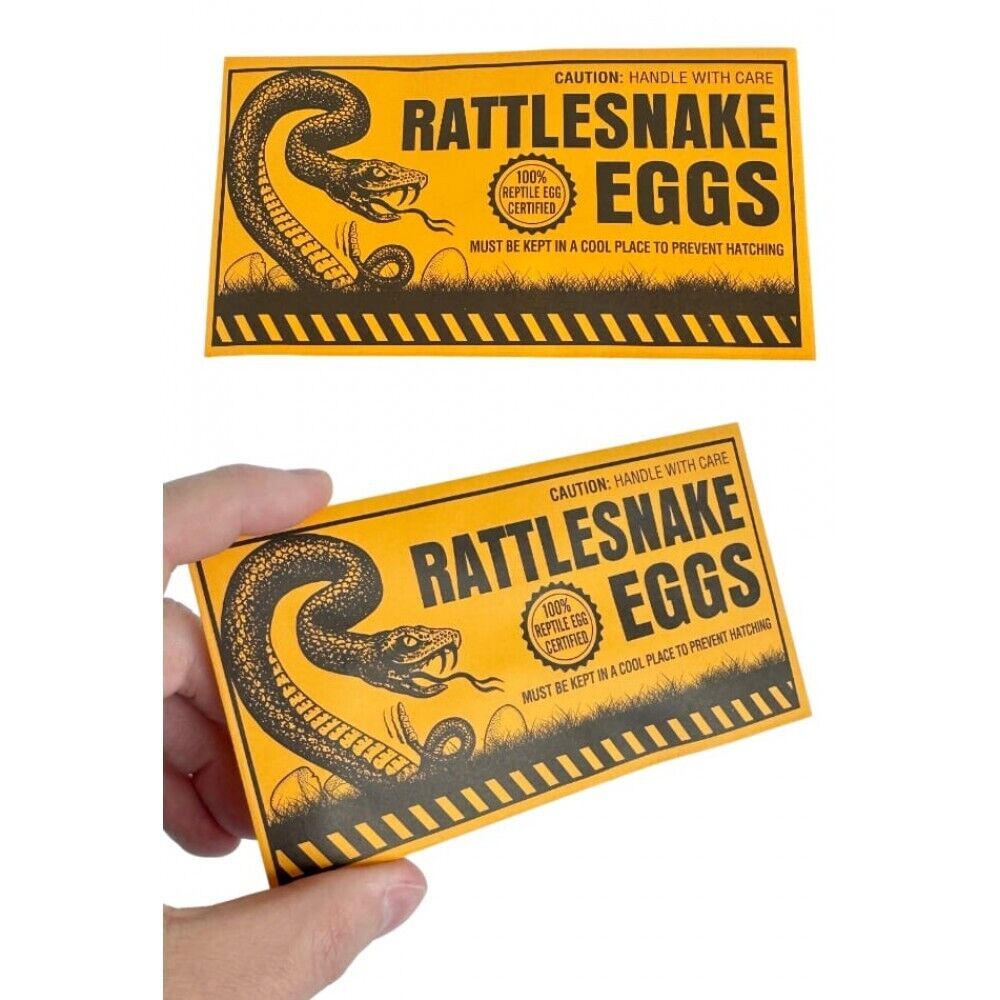 A person holds a yellow envelope labeled "144 Prank Rattlesnake Egg Envelope - Novelty Gag Joke Gift Toy - Wholesale Lot" with a coiled snake illustration and a warning to handle with care—a classic rattlesnake eggs prank perfect for party favors or adding fun to your next event.