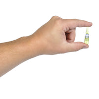 A hand holding a small, clear vial with a yellow label against a white background, resembling one of the classic prank items from the "1 CASE OF 36 STINK BOMBS + 3 FART BOMB BAGS ~ COMBO SET.