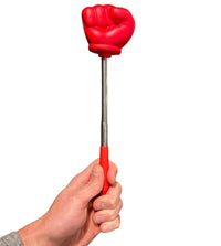 A hand holds the Giant 22" Extending Boxing Punch Glove from Snore-no-More!, a novelty back scratcher with a red fist resembling a funny prank toy.