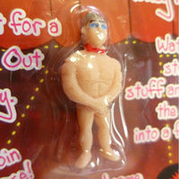 The "Grow Your Own Male Stripper Hunk Man!" is a small plastic male figurine with no clothes, donning a red scarf. Cleverly packaged inside a plastic cover with text partially visible in the background, this funny adult party novelty gag joke gift is perfect for bachelorette parties and will surely bring laughs and fun to the celebration!