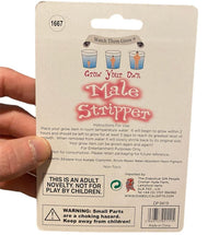 A hand holds packaging labeled "Grow Your Own Male Stripper Hunk Man! Funny Adult Party Novelty Gag Joke Gift" with instructions, safety warnings, and manufacturer information written on it— the perfect gag gift for a bachelorette party.