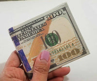 A hand with pink-painted nails holds a 12 Pack - 100 Hundred Dollar Bill Wallets Money Bi-Fold Card Holder, crafted from canvas material, against a white background.