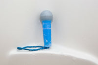 A blue Microphone Soap On Rope with a blue cord attached is positioned against a white, wet surface, perfect for shower concerts by BigMouth Inc.