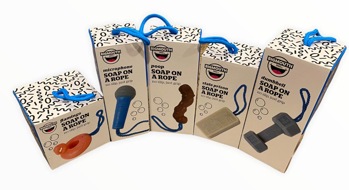 Displayed in their packaging, four novelty "Soap on a Rope" products from BigMouth Inc feature distinctive designs: a life ring, a microphone (ideal for shower concerts and named "Microphone Soap On Rope - Rock on while cleaning up your butt!"), feces, a stone tablet, and a dumbbell. Each soap includes a blue rope handle.