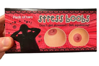 Box labeled "2pk Stress Boobs - Squeeze Boobies Feels Real! Adult Novelty Breast Man Toy Gift" containing two stress balls shaped like breasts. Text reads: "Don't get stressed! Master your juggling technique and start squeezing!" Ideal as a gag gift to bring laughter and relaxation.