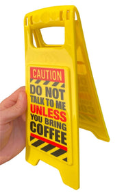 The ⚠️ Funny Warning Bring Coffee Desk Sign ☕️ reads "DO NOT TALK TO ME UNLESS YOU BRING COFFEE." A hand holds the sign—great office humor decor or a fun gag gift for caffeine lovers.