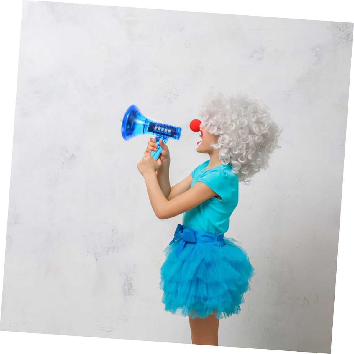 A child in a curly white wig, red clown nose, and blue dress holds the Voice Changer Megaphone Toy – a bullhorn mic with 10 funny sound effects – against a plain light background.