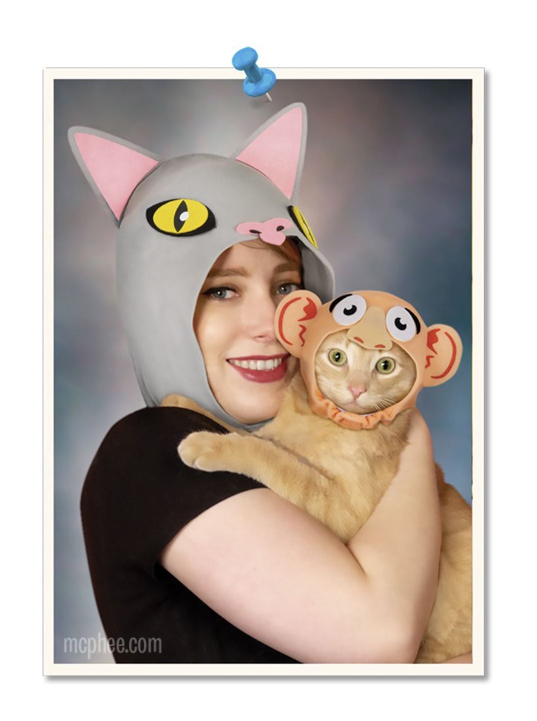 Wearing the Kitty Cat Costume Kit, featuring an owner-to-pet role reversal theme by Archie McPhee, a person dons a cat hood while their feline friend is dressed in a monkey-inspired outfit as they playfully gaze at the camera.