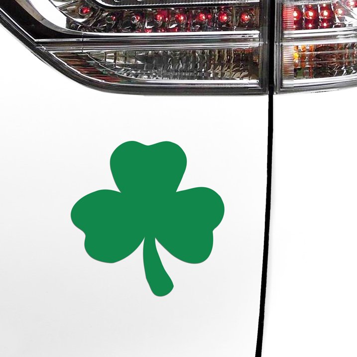 Close-up of a car's tail light with a green shamrock decal from the "12 Shamrock Irish Clover Leaf Car Fridge Kitchen Magnets - Saint Patricks Day" set, adorning the white rear panel and showcasing Irish pride.