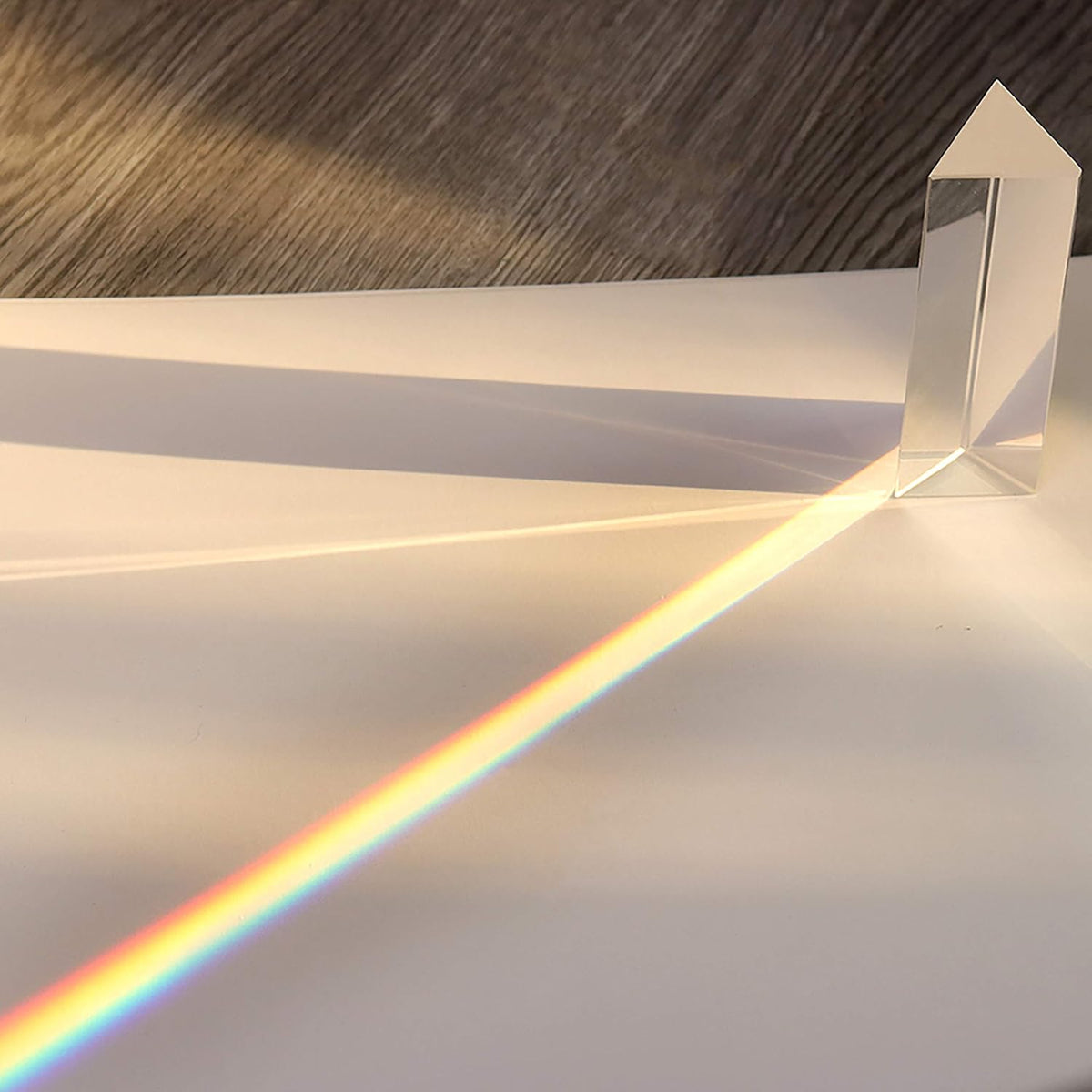 The PRISM - Fun Educational Science Rainbow Light of Colors by Archie McPhee sits on a white surface, employing optics to refract sunlight into a vibrant rainbow spectrum.