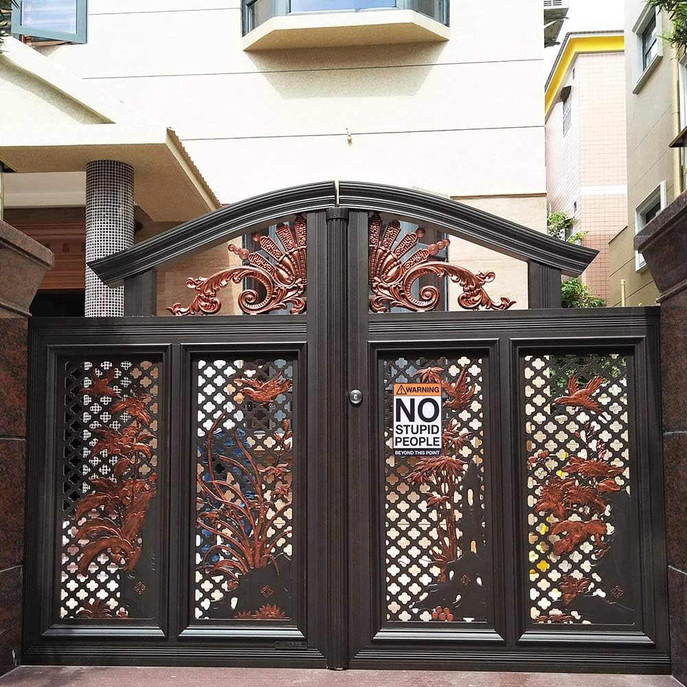 Ornate metal gate with lattice design and decorative elements, showcasing the Metal Tin Sign "Warning: NO STUPID PEOPLE Beyond This Point" Bar Man Cave #C-101. This attention-grabbing sign adds a touch of novelty decor to the entrance.