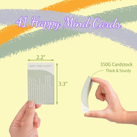 A hand holds a 2.2 x 3.3 inch card from the "40 Positive Daily Quote Cards with Wooden Stand & Tin – Motivational Desk Decor." These thick, sturdy affirmation cards make a thoughtful self-care gift for any occasion.