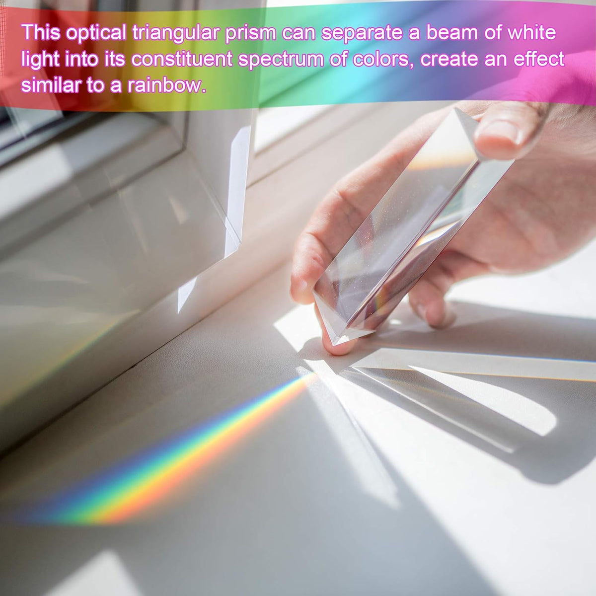 An expert hand holds the PRISM - Fun Educational Science Rainbow Light of Colors by Archie McPhee near a window, scattering light into a vibrant rainbow spectrum across the surface.