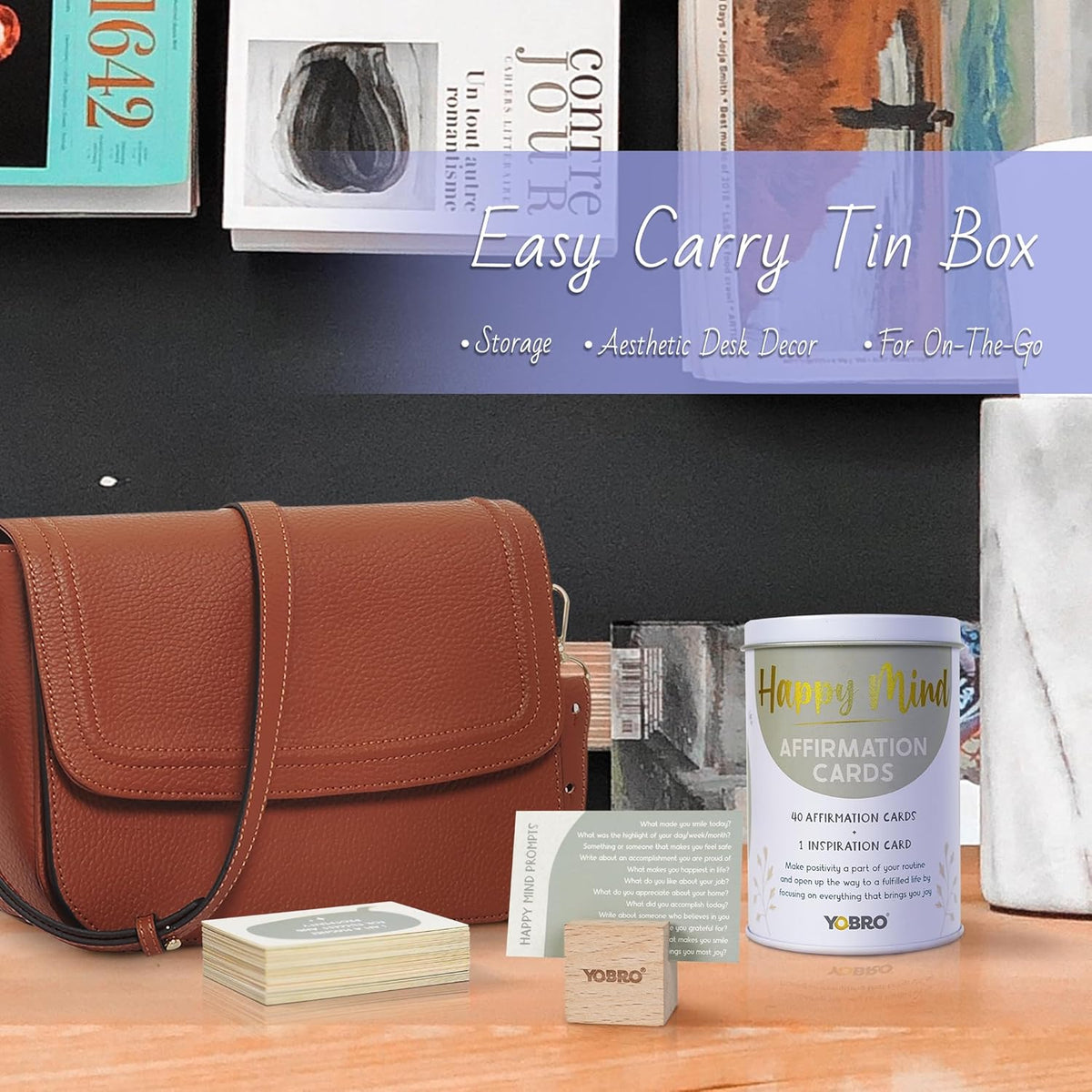 Displayed on a black shelf: a brown leather bag, mental health books, and the "40 Positive Daily Quote Cards with Wooden Stand & Tin – Motivational Desk Decor," promoted as the perfect self-care storage gift in an easy-carry tin box.
