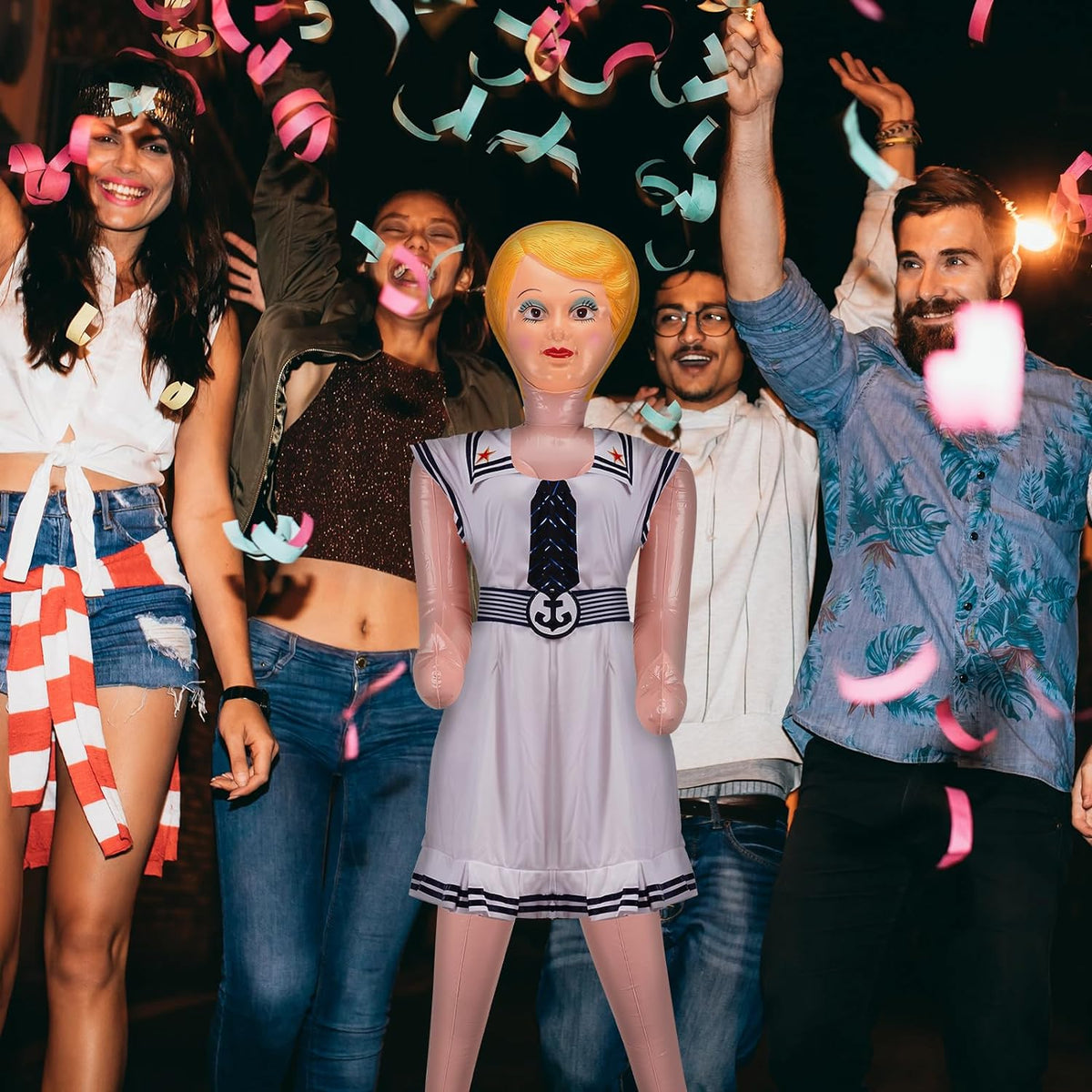 A group of people celebrating at night with colorful confetti in the air and an Inflatable Judy + John Inflate a Date Bachelor/Bachelorette Party Blow Up Doll joining the fun.