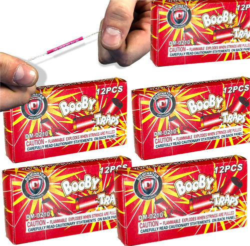 A hand holds a pink-tipped prank string above five boxes labeled "5-PACK - 60 BOOBY TRAP STRINGS 💥 💣 Funny Classic Joke Gag Pranks," each box containing classic prank toys and marked with a flammability warning.