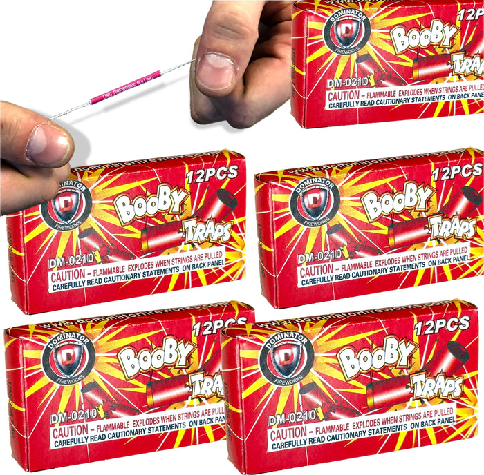 A hand holds a pink-tipped prank string above five boxes labeled "5-PACK - 60 BOOBY TRAP STRINGS 💥 💣 Funny Classic Joke Gag Pranks," each box containing classic prank toys and marked with a flammability warning.