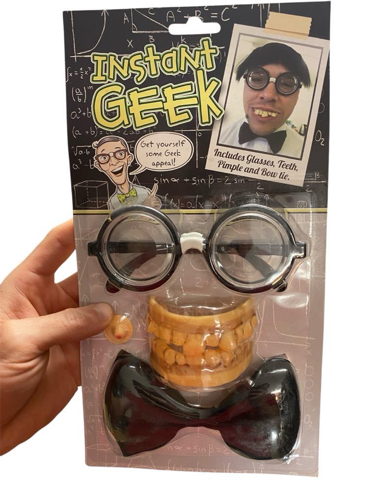 A hand holds the Instant Geek Costume Kit featuring glasses, fake teeth, bow tie & pimple—an all-in-one nerd dress up set with fun gag accessories and a model displaying this novelty gift.