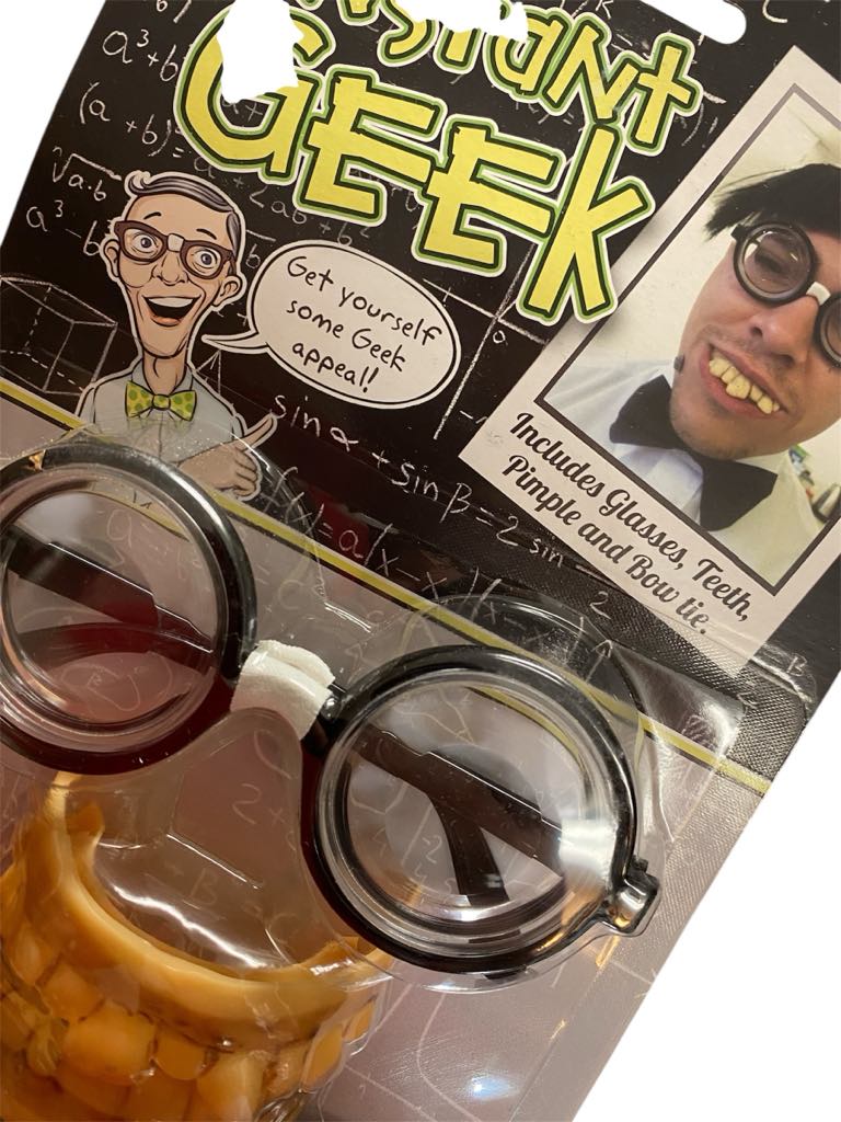 The Instant Geek Costume Kit 🤓 includes glasses, fake teeth, a bow tie, and a pimple—ideal for nerd costumes or gag gifts. Cartoon and photo examples are featured on the packaging.