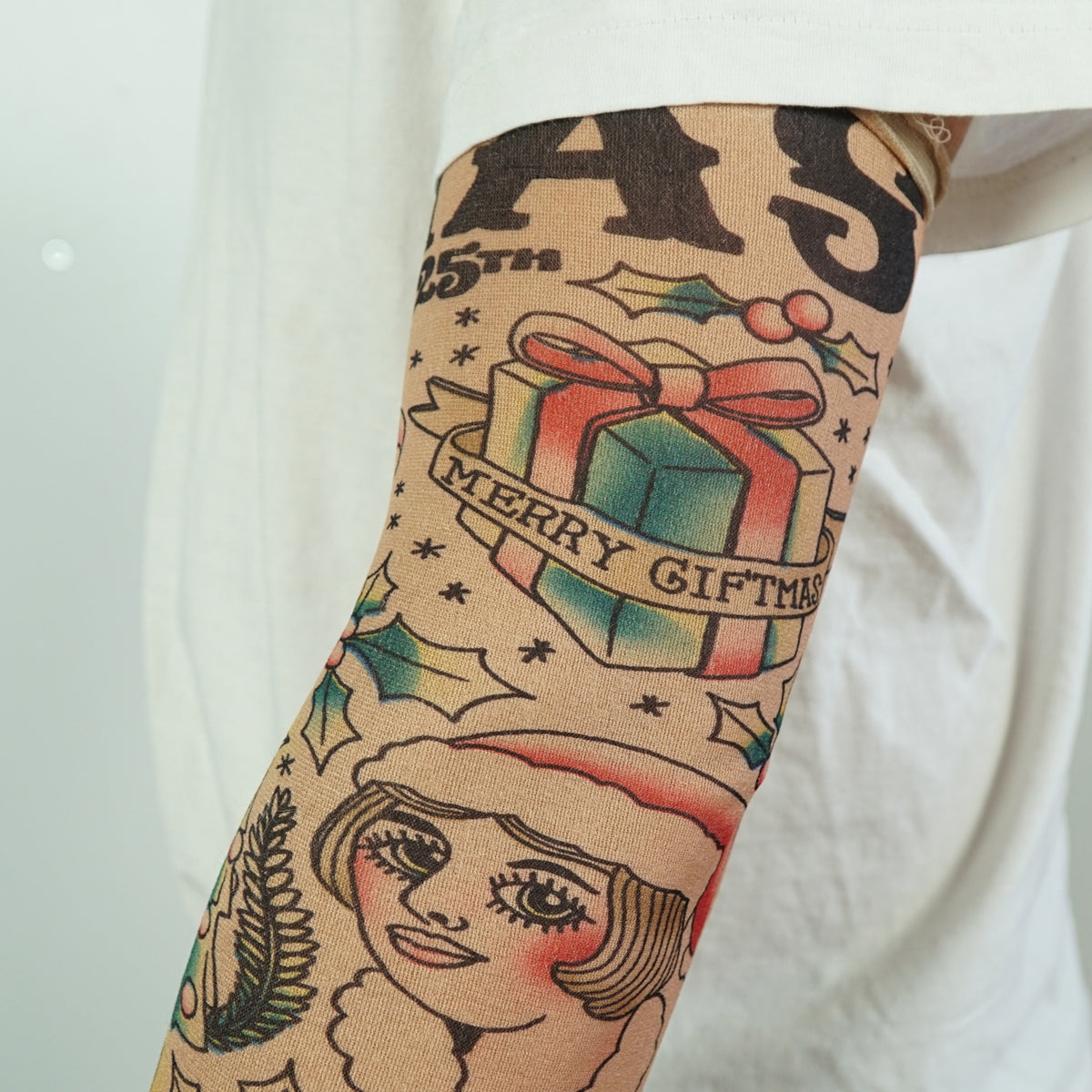 Show off your holiday spirit with the 🎄 Christmas Holiday Tattoo Sleeves 2pk – Funny Fake Arm Tattoos Costume Party🎅, featuring festive designs like "Merry Giftmas" presents, holly, and Santa hat portraits—perfect for any Christmas party or costume!.