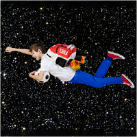 A boy with a Kids Jetpack Backpack Rocket School Bag appears to fly with a soccer ball through a starry space background, wearing blue pants and red sneakers.