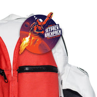 The Kids Jetpack Backpack Rocket School Bag features a round astronaut sticker with "Jetpack Backpack Take Off For School" on the red and white front pocket—perfect for school, travel, or as a space-themed gift!.