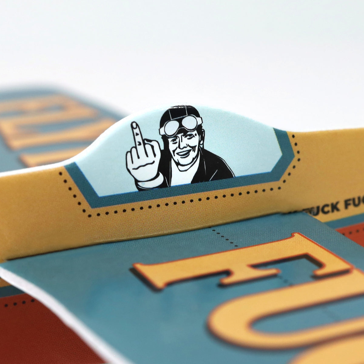 A close-up of a cartoon pilot on a funny foam airplane, smiling and making an obscene gesture. The ✈️🤣 FLYING FU%K – The Mini Plane Glider That Says It All! 🙌😂 is the ultimate adult gag gift for aviation humor fans.