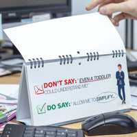 As a hand flips a page on the "Professional Insults - Desk Spiral Flip Book - Funny Office Message Table Signs," it provides communication tips, recommending against workplace comebacks such as "Even a toddler could understand me" and suggesting the HR-approved alternative "Allow me to simplify.