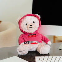 The Punchkins "Cute But PSYCHO" teddy bear plushie, holding a bloody kitchen knife, sits on a desk by a monitor—this sassy and funny stuffed animal makes the perfect edgy gift.