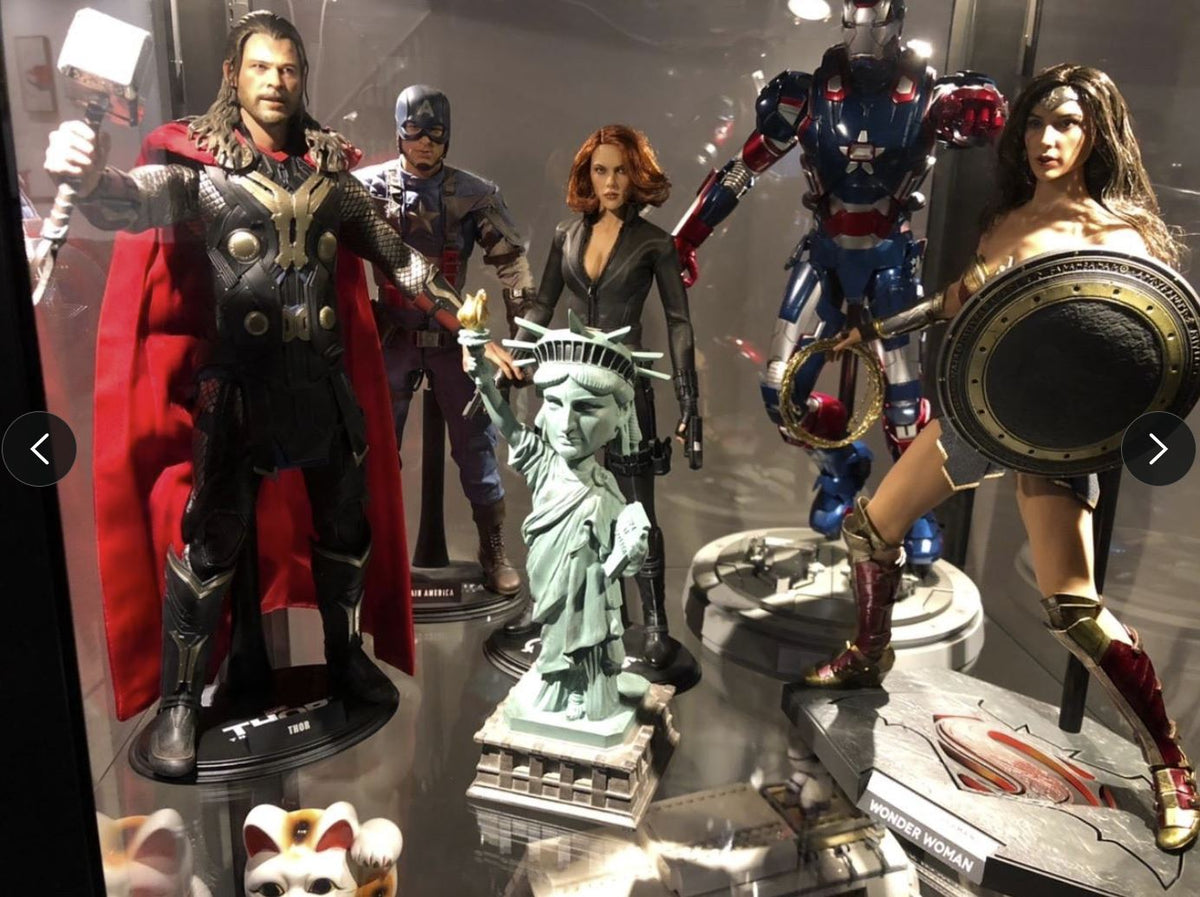 Action figures of Thor, Captain America, Black Widow, Iron Patriot, Wonder Woman, and a Statue of Liberty Bobblehead Figure 🗽 – Premium Lifelike Collectible Decor Gift are displayed in a glass case.
