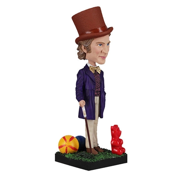 The Willy Wonka Bobblehead Statue – Gene Wilder Collectible Figure by Royal Bobbles🍬 features a hand-painted Willy Wonka in a purple coat and brown top hat, standing on a grassy base with a cane, ball, and giant gummy bear.