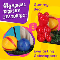 A display featuring a large red gummy bear, two colorful everlasting gobstoppers, and the Willy Wonka Bobblehead Statue – Gene Wilder Collectible Figure by Royal Bobbles🍬 on a vibrant yellow background.